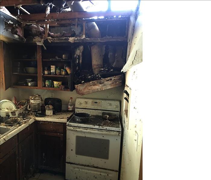 fire damaged in a kitchen, debris, hole in the roof